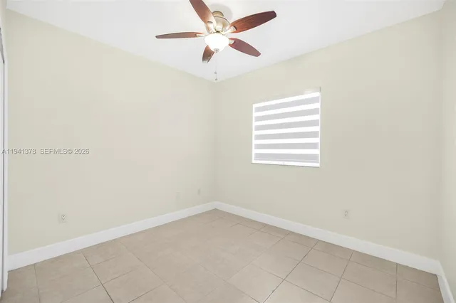 an empty room with a window and a fan