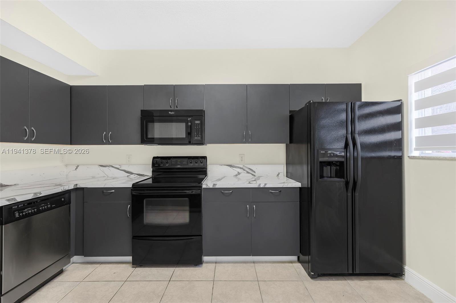 8331 Southwest 124th Avenue, Unit 10414 Miami, FL 33183 - Photo 6 of 24 a kitchen with a refrigerator and a stove