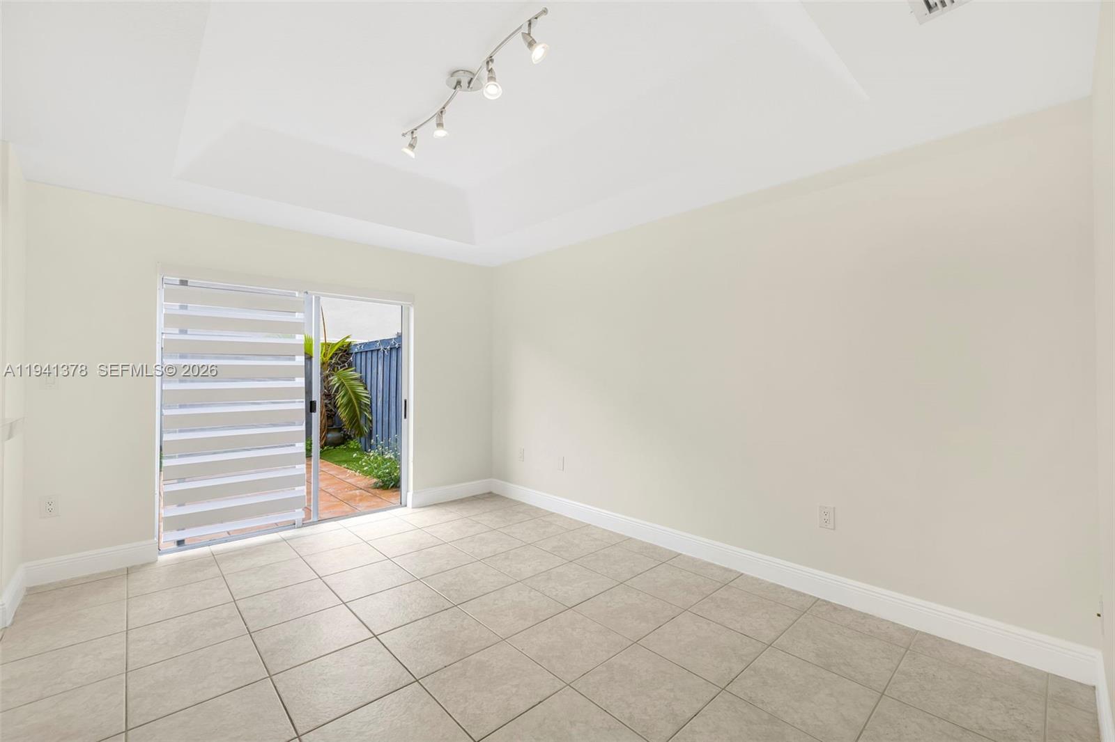 8331 Southwest 124th Avenue, Unit 10414 Miami, FL 33183 - Photo 9 of 24 a view of an empty room with a window and wooden floor