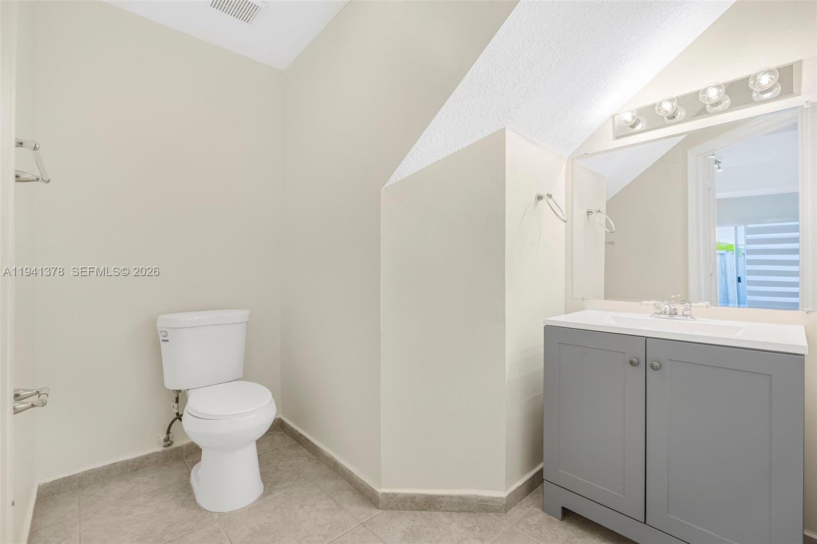 8331 Southwest 124th Avenue, Unit 10414 Miami, FL 33183 - Photo 10 of 24 a bathroom with a toilet sink and mirror