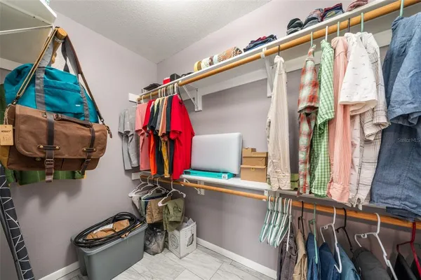 a view of walk in closet with clothes and shoes