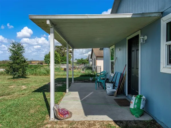 a view of a porch with a table and chairs under an umbrella