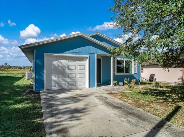 a view of a house with backyard and a tree