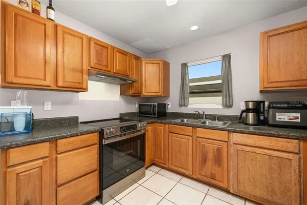 a kitchen with stainless steel appliances granite countertop a sink stove and cabinets