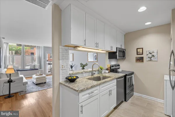 a kitchen with stainless steel appliances granite countertop a sink stove and cabinets
