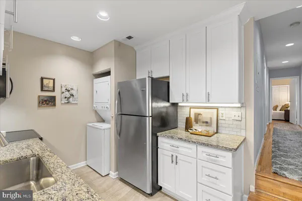 a kitchen with granite countertop a refrigerator a stove a sink and dishwasher