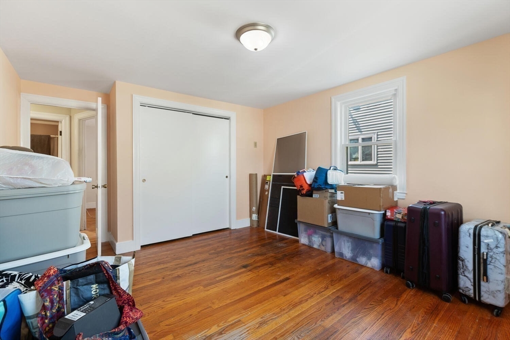 152 Springvale Avenue Everett, MA 02149 - Photo 18 of 30 a bedroom with a bed and wooden floor