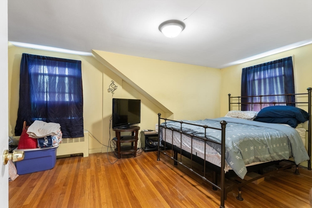 152 Springvale Avenue Everett, MA 02149 - Photo 21 of 30 a bedroom with a bed and wooden floor