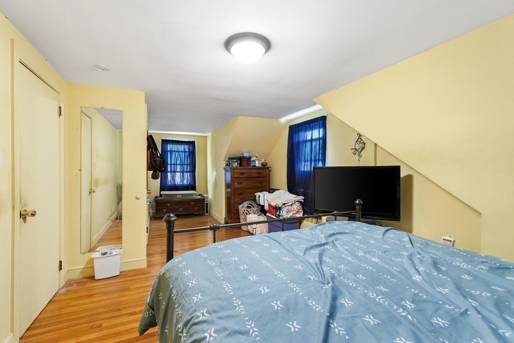 152 Springvale Avenue Everett, MA 02149 - Photo 22 of 30 a bedroom with a bed and wooden floor