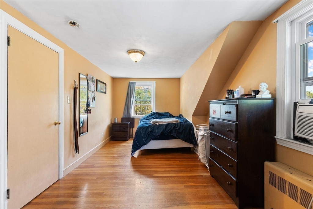 152 Springvale Avenue Everett, MA 02149 - Photo 26 of 30 a bedroom with a bed and wooden floor