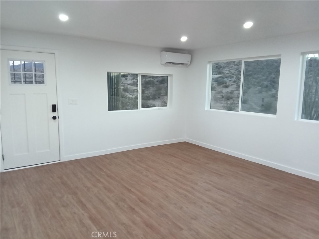 66954 Appian Way Joshua Tree, CA 92252 - Photo 12 of 26 an empty room with wooden floor and windows