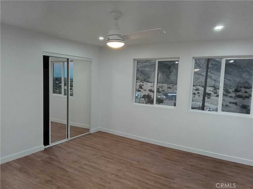 66954 Appian Way Joshua Tree, CA 92252 - Photo 17 of 26 an empty room with wooden floor and windows