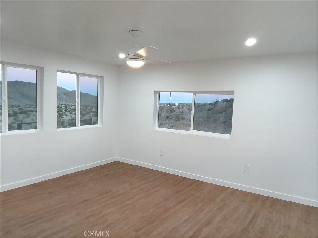 66954 Appian Way Joshua Tree, CA 92252 - Photo 18 of 26 an empty room with wooden floor and windows