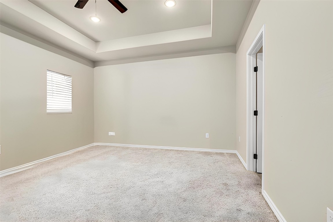 10040 Shepard Hill Road Willis, TX 77318 - Photo 27 of 36 This is a spacious, neutral-toned room with carpet flooring, recessed ceiling lighting, and a ceiling fan. It features a window with blinds for natural light and a doorway leading to another space, offering a versatile area for various uses.