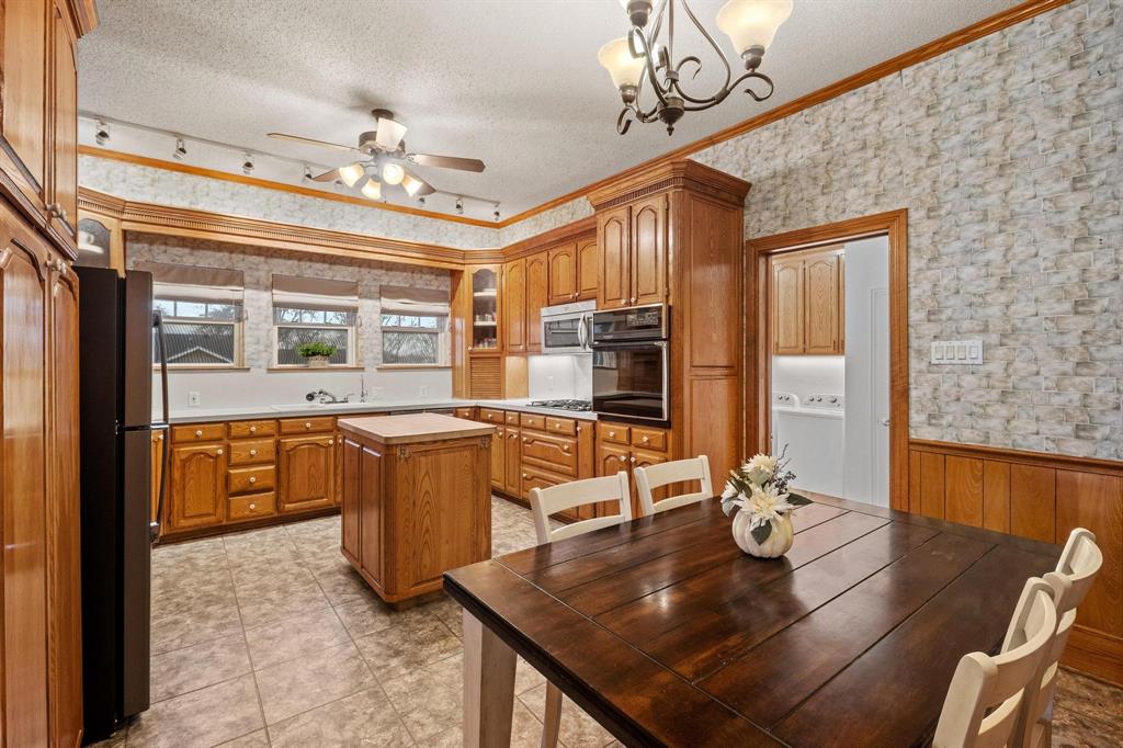 715 East 5th Street Ferris, TX 75125 - Photo 15 of 40 a dining room with furniture a chandelier and wooden floor