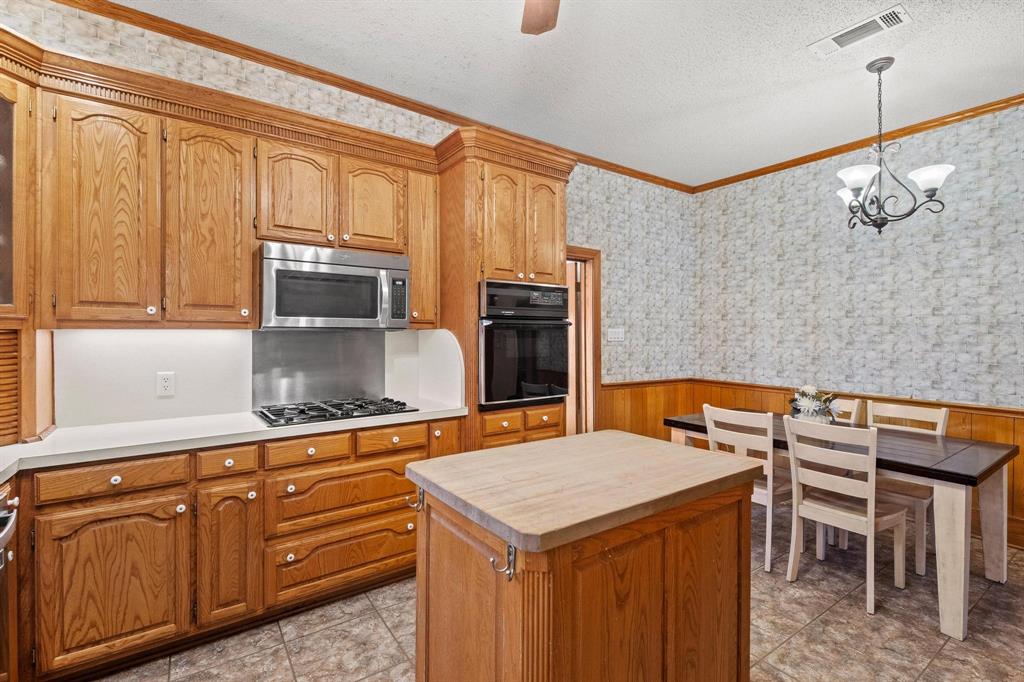 715 East 5th Street Ferris, TX 75125 - Photo 17 of 40 a kitchen with stainless steel appliances a stove a sink cabinets and a refrigerator