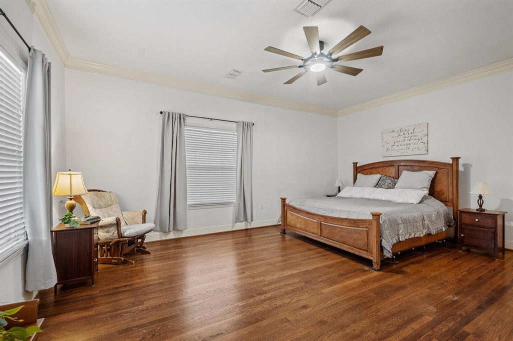 715 East 5th Street Ferris, TX 75125 - Photo 18 of 40 a bedroom with a bed and wooden floor