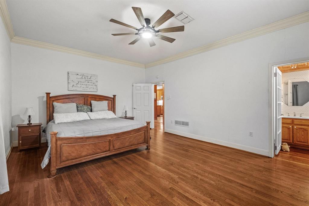 715 East 5th Street Ferris, TX 75125 - Photo 19 of 40 a bedroom with a bed and wooden floor