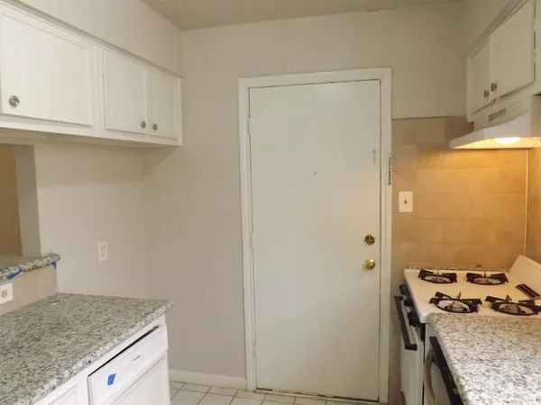 a view of an empty room and chandelier fan