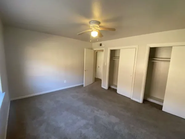 a bedroom with a bed and a ceiling fan