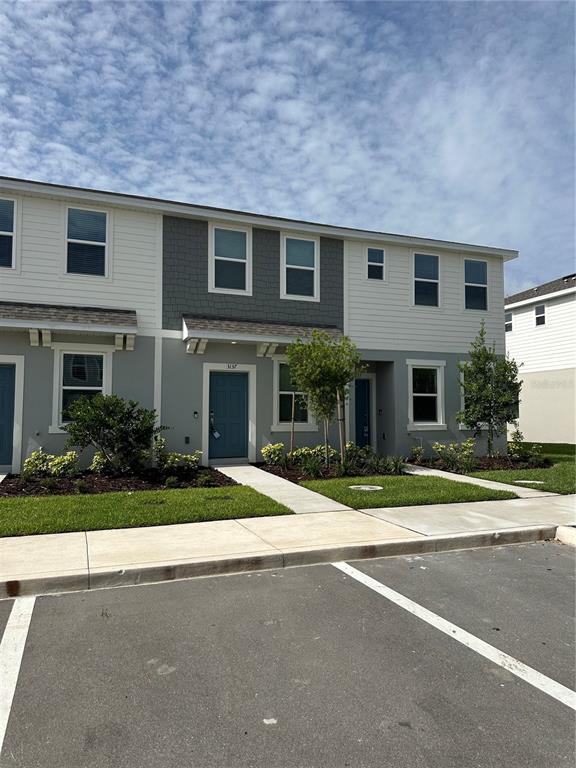 3137 Skyline Loop Kissimmee, FL 34758 - Photo 1 of 14 a front view of a house with a yard and a garage