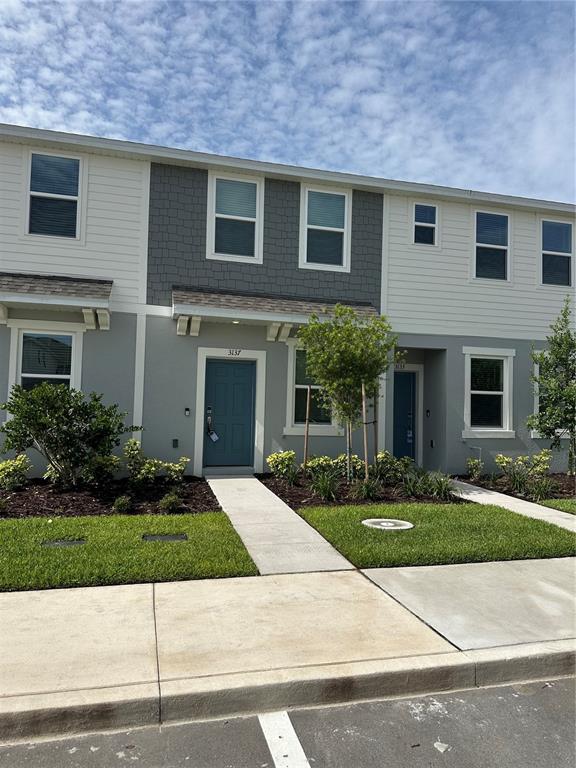 3137 Skyline Loop Kissimmee, FL 34758 - Photo 2 of 14 a front view of a house with a yard and garage