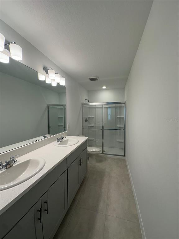 3137 Skyline Loop Kissimmee, FL 34758 - Photo 5 of 14 a bathroom with a double vanity sink and mirror