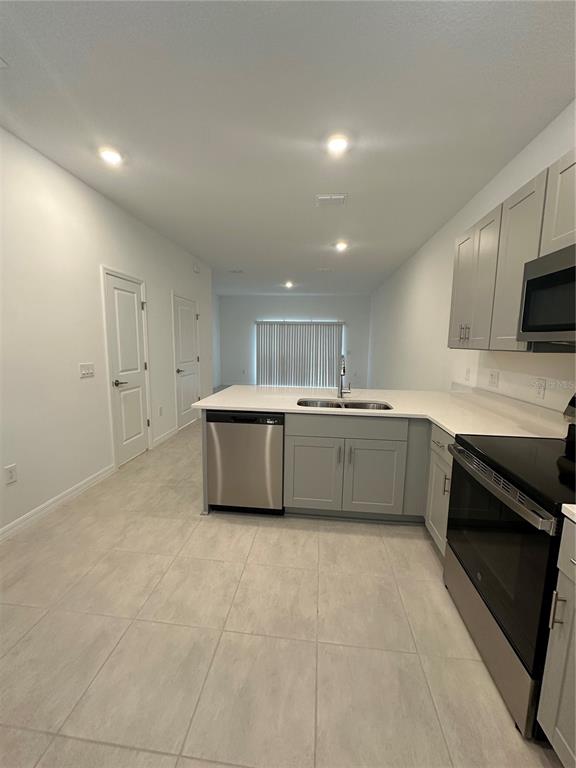 3137 Skyline Loop Kissimmee, FL 34758 - Photo 7 of 14 a large white kitchen with a sink and dishwasher a stove top oven with wooden floor