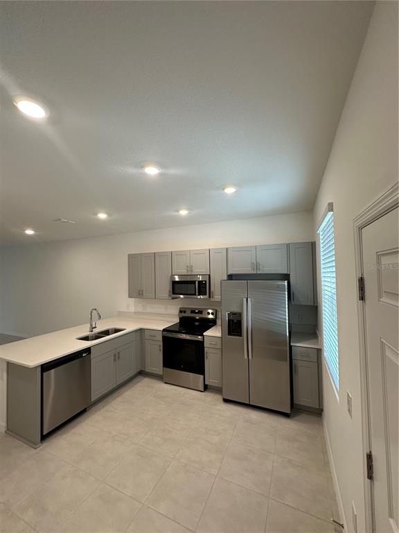 3137 Skyline Loop Kissimmee, FL 34758 - Photo 9 of 14 a large kitchen with a stove a refrigerator and a sink