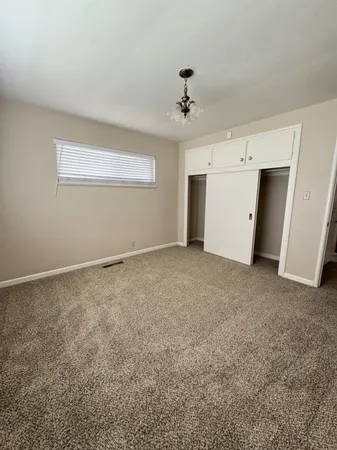 a spacious bedroom with a bed and a mirror