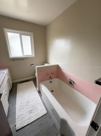 a view of empty room with wooden floor and fence