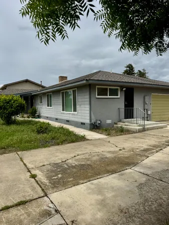a front view of a house with a garden