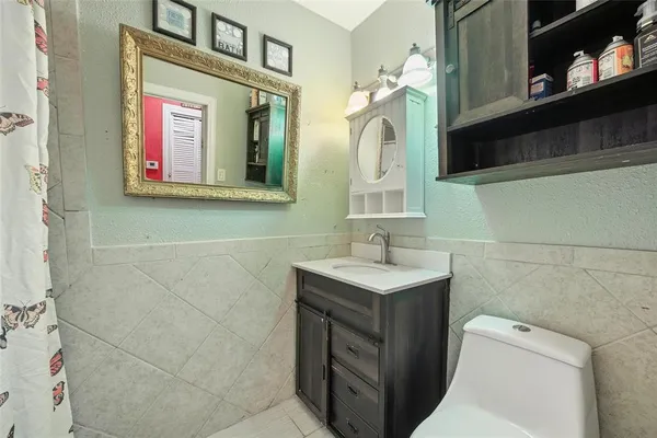 a bathroom with a toilet sink and mirror