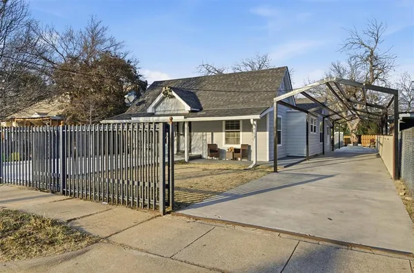 a view of a white house with wooden fence