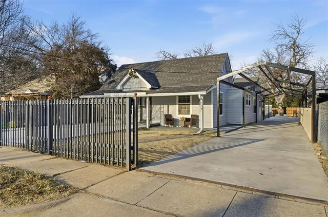 a view of a white house with wooden fence