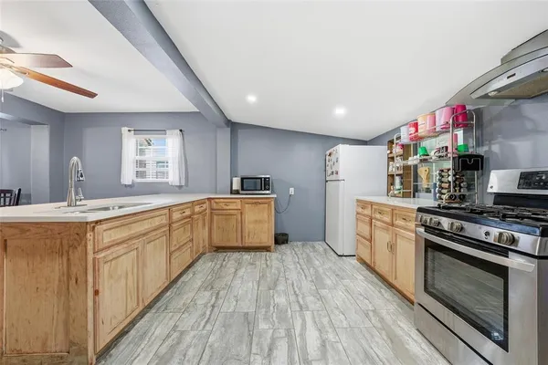 a kitchen with stainless steel appliances granite countertop a stove a sink dishwasher and a refrigerator