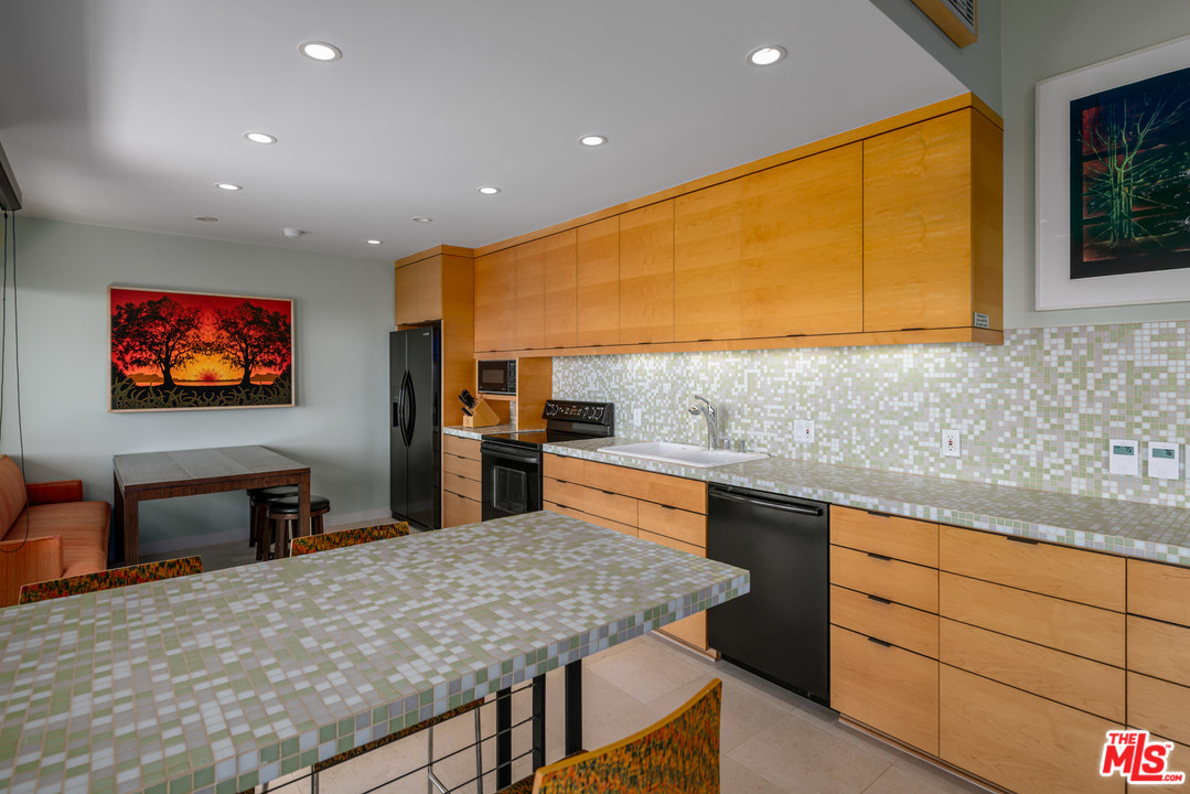 6789 Shearwater Lane Malibu, CA 90265 - Photo 19 of 21 a kitchen with stainless steel appliances granite countertop a sink counter space and a stove top oven