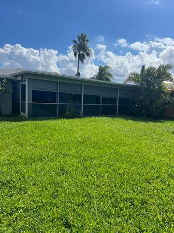 a view of a house with a yard and potted plants