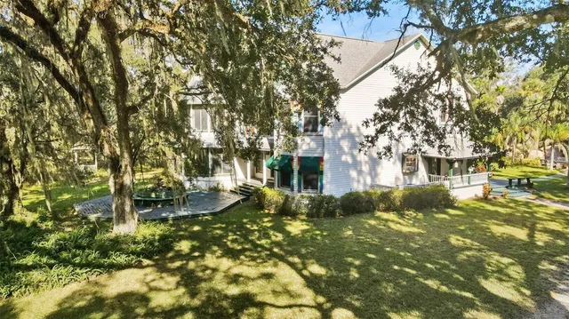 an aerial view of house with yard and mountain view in back
