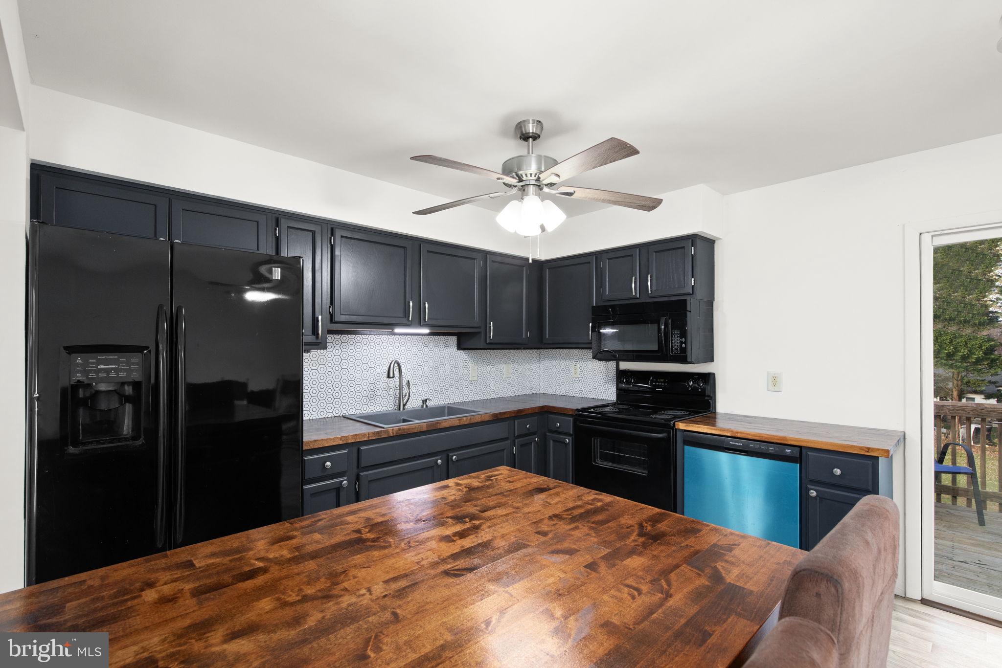 148 Sharon Street Rising Sun, MD 21911 - Photo 12 of 43 a kitchen with stainless steel appliances kitchen island granite countertop a refrigerator stove top oven and sink