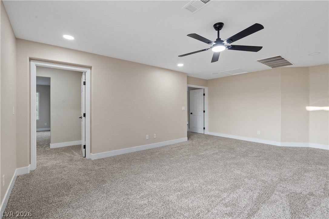 1662 Ravanusa Drive Henderson, NV 89052 - Photo 24 of 74 A spacious room offers ample space, illuminated by recessed lighting and a ceiling fan.