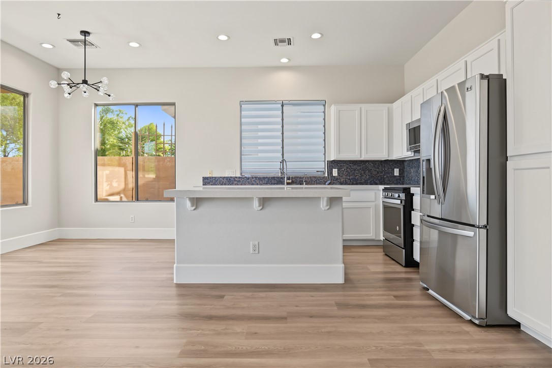 6 Mohansic Road Henderson, NV 89052 - Photo 9 of 38 Clean lines and recessed lighting define this open-plan culinary space with wood flooring.