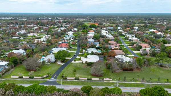 an aerial view of residential houses with outdoor space and trees