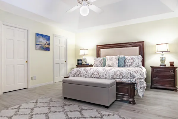 a bedroom with a large bed and a chandelier