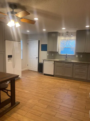 a large kitchen with stainless steel appliances granite countertop a sink and cabinets