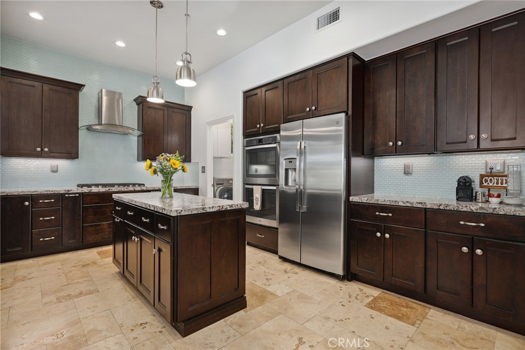 7 Wegeford Circle Ladera Ranch, CA 92694 - Photo 15 of 74 a kitchen with stainless steel appliances granite countertop wooden cabinets a refrigerator and a sink