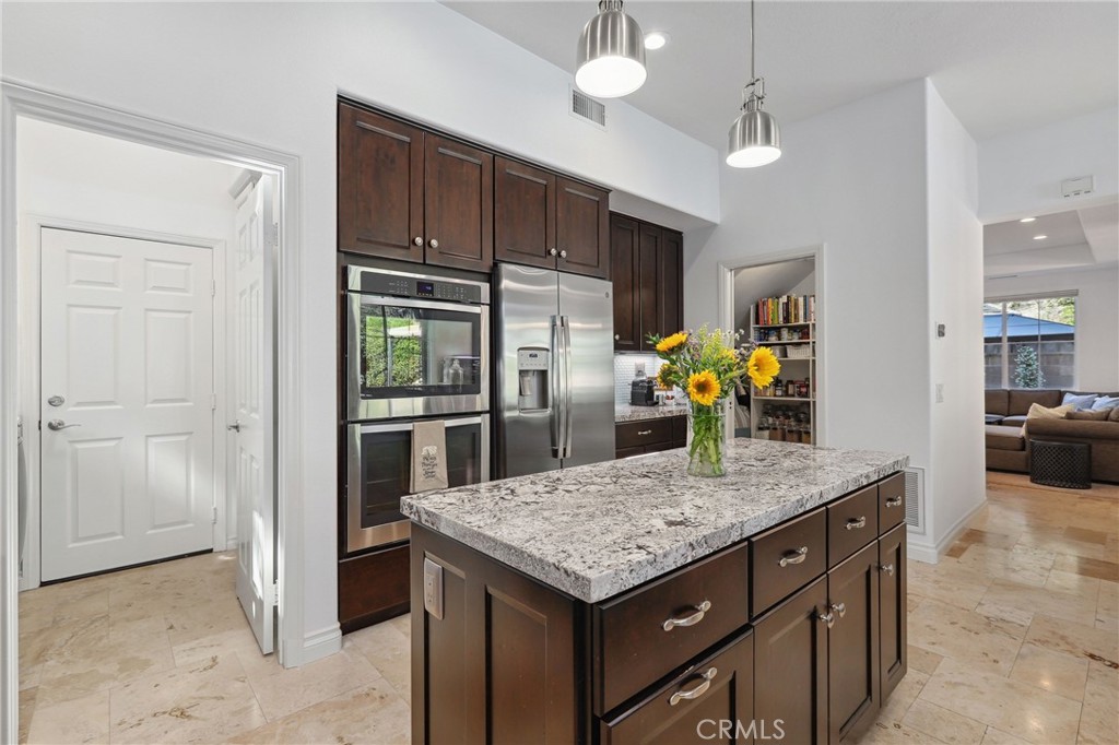 7 Wegeford Circle Ladera Ranch, CA 92694 - Photo 18 of 74 a kitchen with stainless steel appliances granite countertop wooden cabinets a refrigerator and a stove