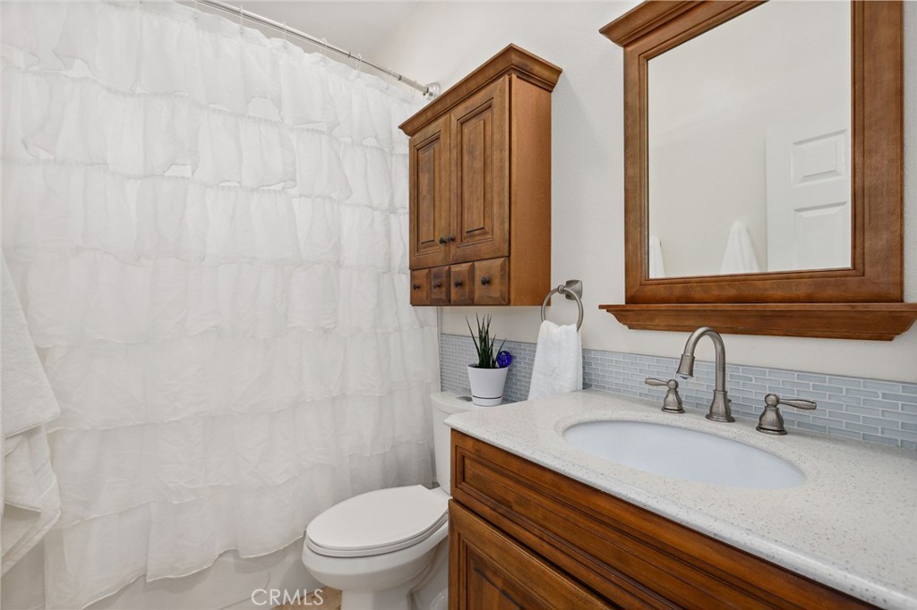 7 Wegeford Circle Ladera Ranch, CA 92694 - Photo 36 of 74 a bathroom with a granite countertop sink a toilet and a mirror