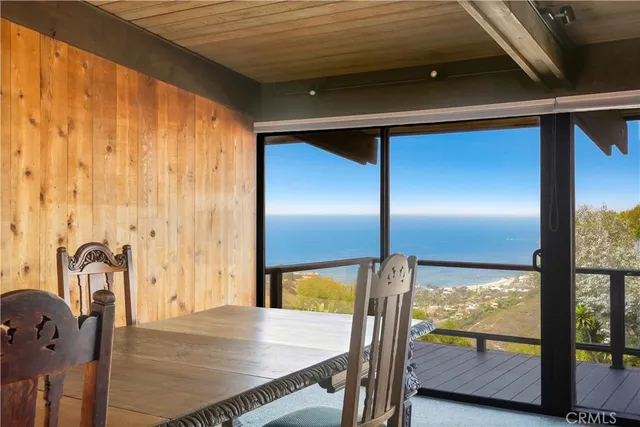 a dining room with furniture and a floor to ceiling window