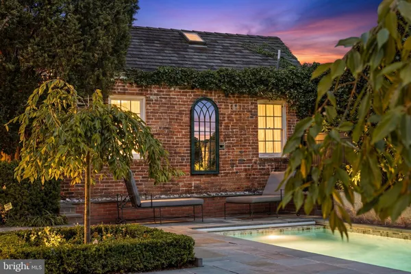 a view of a brick house with a yard and plants
